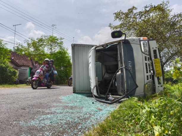 KECELAKAAN TUNGGAL: Truk boks yang dikemudikan Sepri Prastiyono terguling di Jalan Desa Mojorejo, Kecamatan Pace kemarin. Arus lalu lintas menjadi terganggu. (Foto: Oktavia Rahajeng)