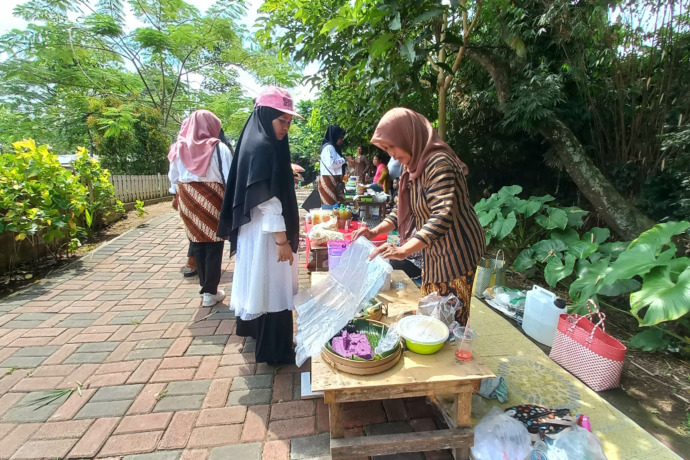 GELIAT EKONOMI: Siti melayani pembeli di kawasan wisata Goa Jegles Desa Keling, Kecamatan Kepung. Keberadaan wisata desa iku mendongkrak perekonomian dan UMKM. (Foto: Andhika Attar)