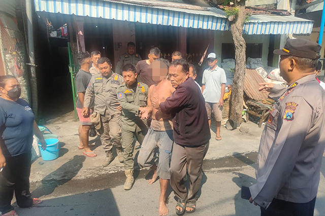 BUTUH PERAWATAN: Personel Satpol PP Kota Kediri mengamankan M. Toha yang mengamuk di Kelurahan Bangsal, Kecamatan Pesantren kemarin. Setelah diamankan, petugas membawanya ke RS Bhayangkara Kediri.