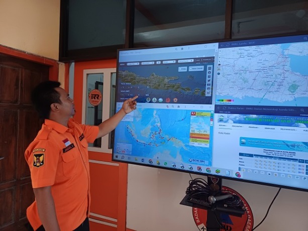 MONITOR: Operator Pusdalops BPBD Kota Kediri Jaenal Arifin memantau titik panas melalui peta SipongiPlus yang menampilkan laporan secara realtime.&nbsp;(Foto: Ayu Isma/JPRK)