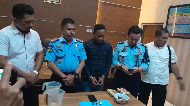 TEGAS: Kalapas Kelas II A Kediri Muhammad Hanafi (2 dari kiri) bersama Kasatresnarkoba AKP Ipung Herianto (kiri) menunjukkan tiga paket SS yang berusaha diselundupkan oleh Bambang (tangan diborgol), dalam rilis di lapas kemarin siang. (Foto: Emilia Susant