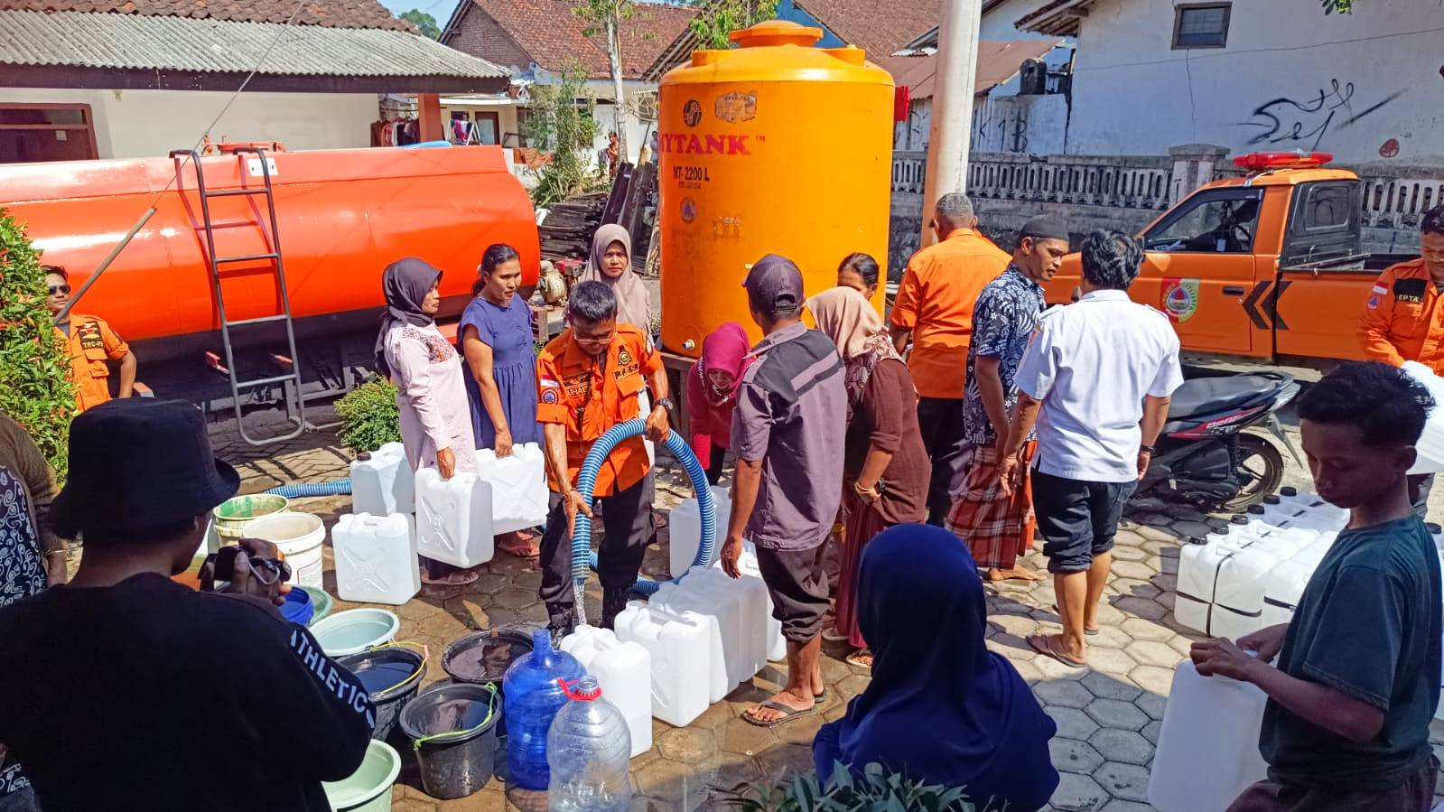 HEMAT AIR: Warga yang sumurnya mulai kering di wilayah Kecamatan Patrang antre untuk mendapatkan air bersih yang dipasok Badan Penanggulangan Bencana Daerah (BPBD) Jember, Selasa (20/6).