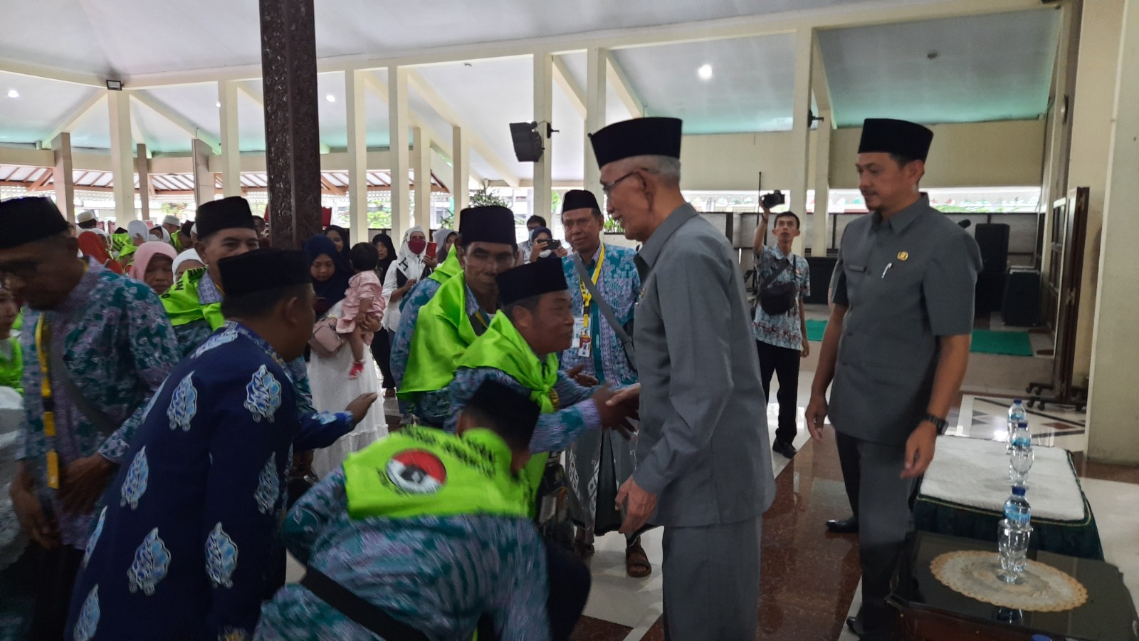 MOMEN HARU: Bupati Bondowoso Drs KH Salwa Arifin bersalaman dengan jemaah haji sebelum keberangkatan ke Tanah Suci, Kamis (22/6).