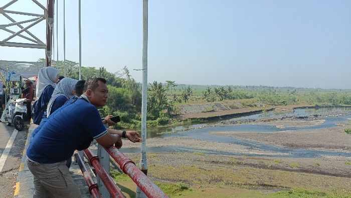 SINGGAH: Tampak satu rombongan yang menggunakan seragam sama singgah dan menikmati pemandangan di Jembatan sambil melepas lelah.&nbsp; FOTO: HASBY/RADAR SEMERU