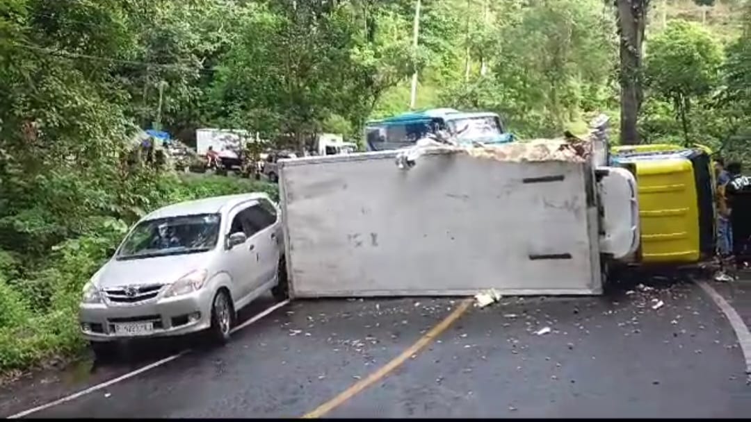 MENUTUP JALAN: Truk boks pengangkut ikan yang terguling di jalur Gumitir, Desa Sidomulyo, Kecamatan Silo, Jember, Selasa (27/6).
