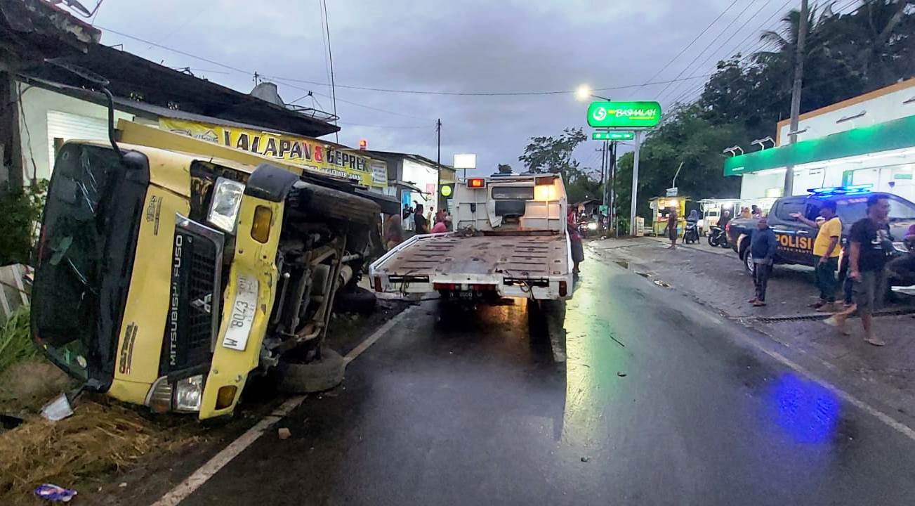 PROSES PENGANGKATAN: Kendaraan towing bersiap membawa truk boks yang mengalami kecelakaan di Jalan PB Sudirman Dusun Mencek, Desa Serut, Kecamatan Panti, Jember, Sabtu (1/7) sore.