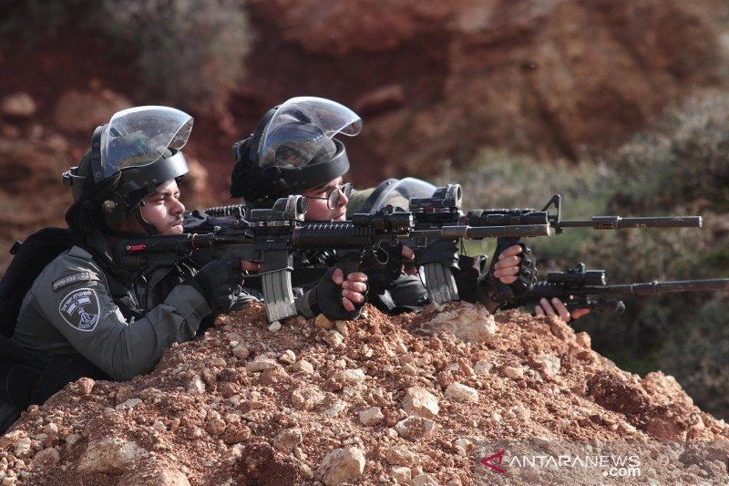 Arsip - Polisi perbatasan Israel meneropong dengan senjata mereka selama bentrokan dengan para pengunjuk rasa Palestina di Desa Beit Dajan di timur Kota Nablus, Tepi Barat, Jumat (18/12/2020)