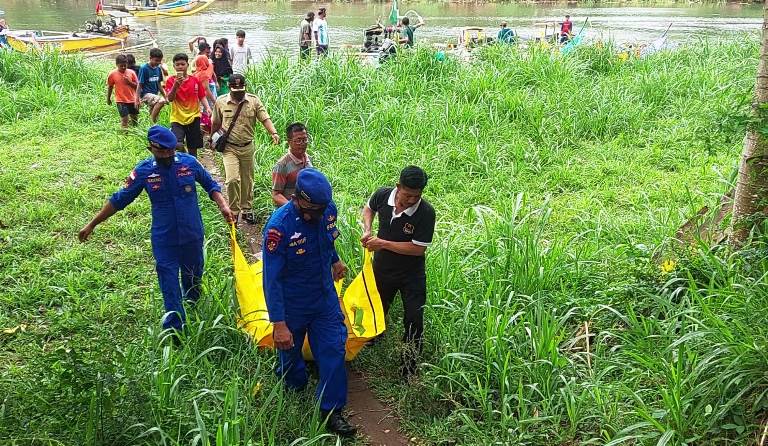 EVAKUASI: Personel Satpolair Polres Jember di Puger membawa jenazah perempuan yang ditemukan mengambang di Sungai Bedadung, Selasa (4/7).