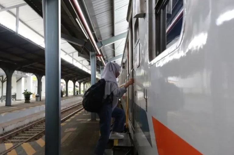 ILUSTRASI: Salah seorang pengguna kereta api saat akan menaiki gerbong kereta.