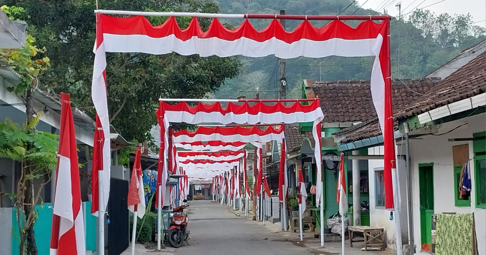 SEMARAK: Susana gang desa di Jenggawah, Jember sudah ramai hiasan bendera merah putih. (JUMAI/RADAR JEMBER)