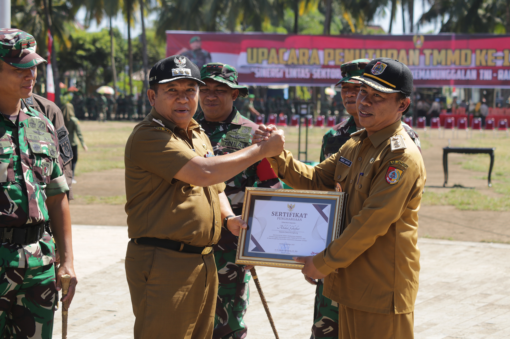 PENOBATAN: Bupati Jember Hendy Siswanto memberikan piagam penetapan Desa Klungkung dari desa tertinggal menjadi desa mandiri seusai upacara penutupan TMMD Ke-117 Kodim 0824/