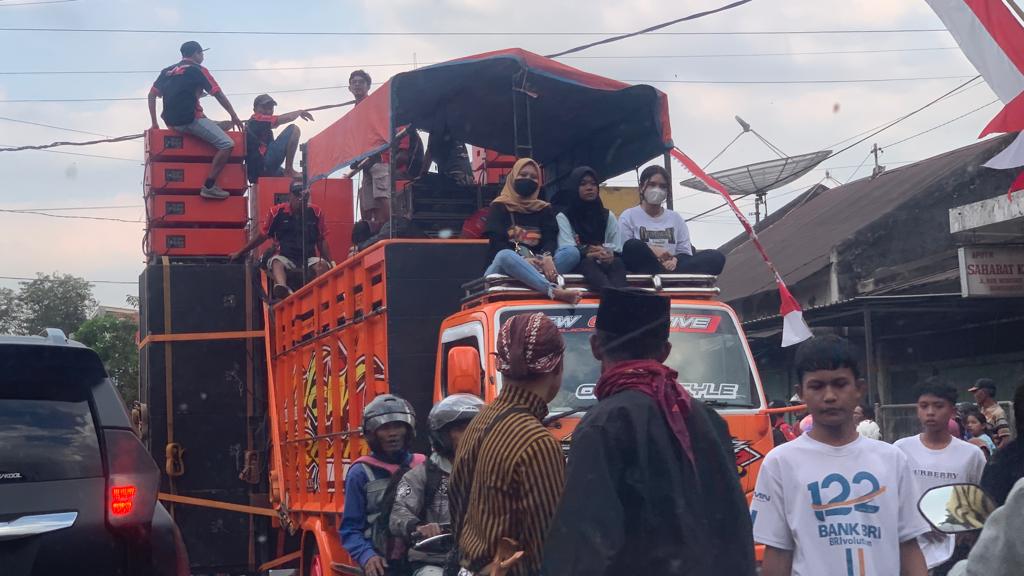 BERBAHAYA: Masyarakat menaiki truk bermuatan sound system di Desa/Kecamatan Wonosari, Minggu (13/8).