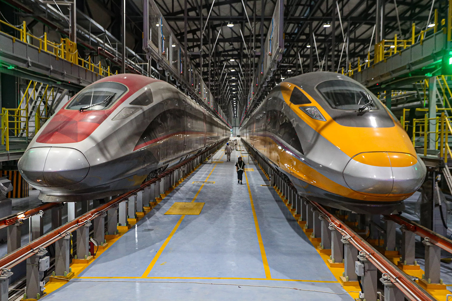 tampak pekerja sedang melintas di dekat rangkaian Electric Multiple Unit (EMU) di Depo Kereta Cepat Tegalluar, Kabupaten Bandung, Jawa Barat.