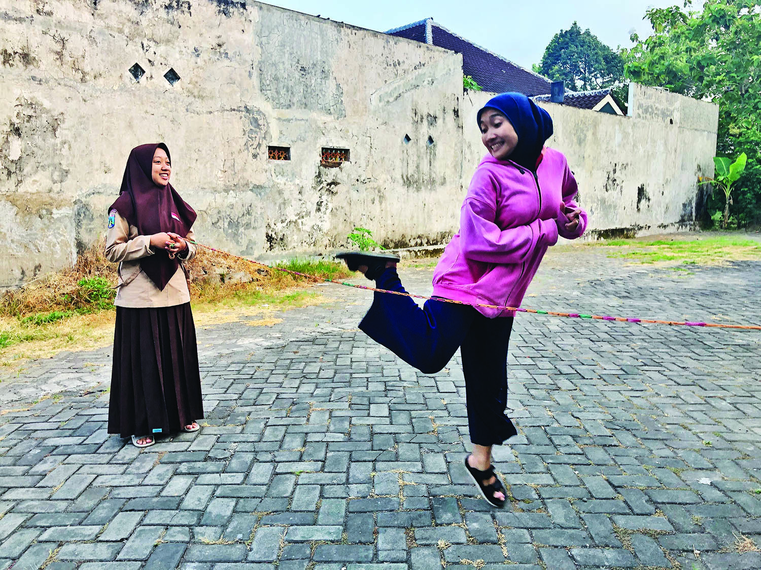 RINTANGAN: Seorang anak berusaha melompati tahapan yang ditentukan dalam permainan tali karet.