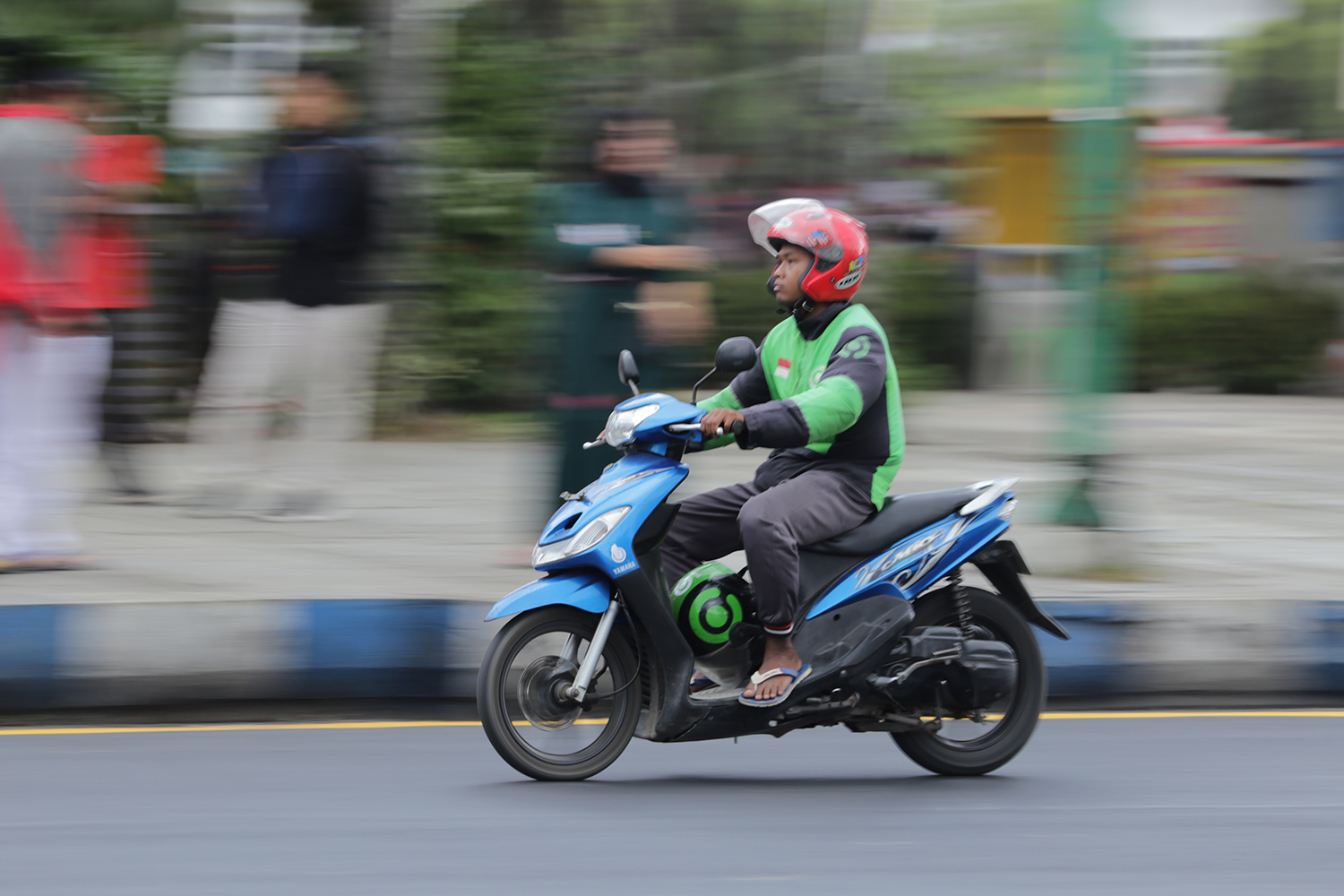 MELAJU: Driver ojek online melintas di sekitar Alun-Alun Jember.