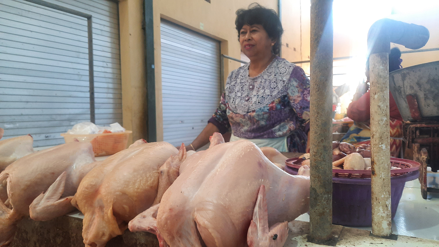 MELAYANI: Sugiarti semringah lantaran harga daging ayam ras kembali normal, kemarin (21/8).