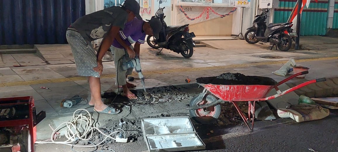 LEMBUR: Tenaga kerja perbaikan trotoar menyelesaikan pekerjaan hingga petang, Rabu malam (23/8).