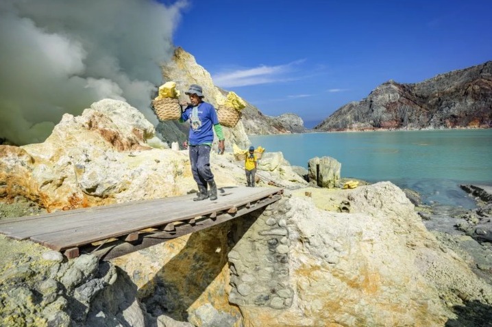 Seorang pekerja membawa sulfur di kawah Ijen.