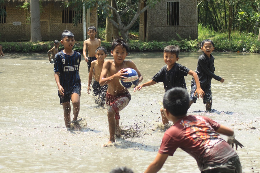 SERU: Anak-anak bermain polo lumpur di Desa Sumberlesung, Kecamatan Ledokombo.