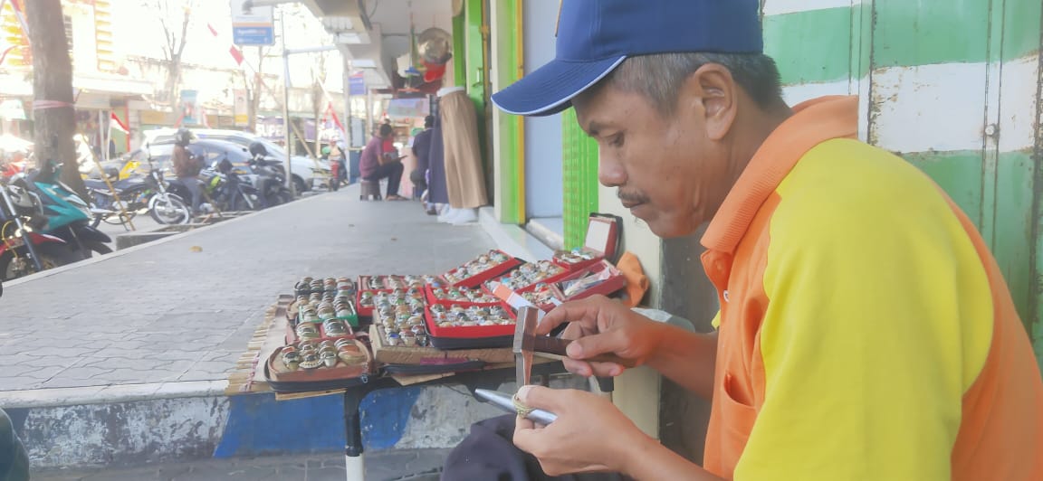 SIBUK: Samsul Arifin, penjual batu akik, sibuk memperbaiki batu akik yang rusak, kemarin (28/8).