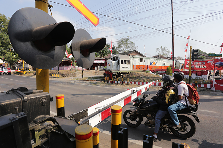 DITUTUP: Pengendara motor berhenti diperlintasan kereta api saat kereta api akan melintas.  &nbsp;ketika kereta api hendak melintas perlintasan kereta api yang sudah tertutup
