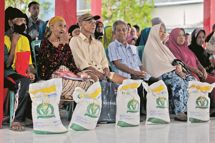 BANTUAN PANGAN: Bupati Jember Hendy Siswanto menyalurkan bantuan 10 kilogram beras dari pemerintah pusat kepada warga Kelurahan Kaliwates, Jumat (15/9).