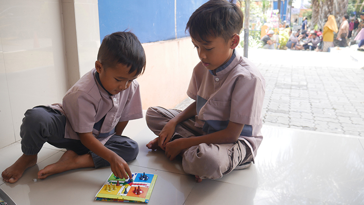 ASYIK: Dua anak-anak tengah bermain Ludo. Permainan ini sekarang masih tetap dimainkan. Karena ada banyak makna di dalamnya.