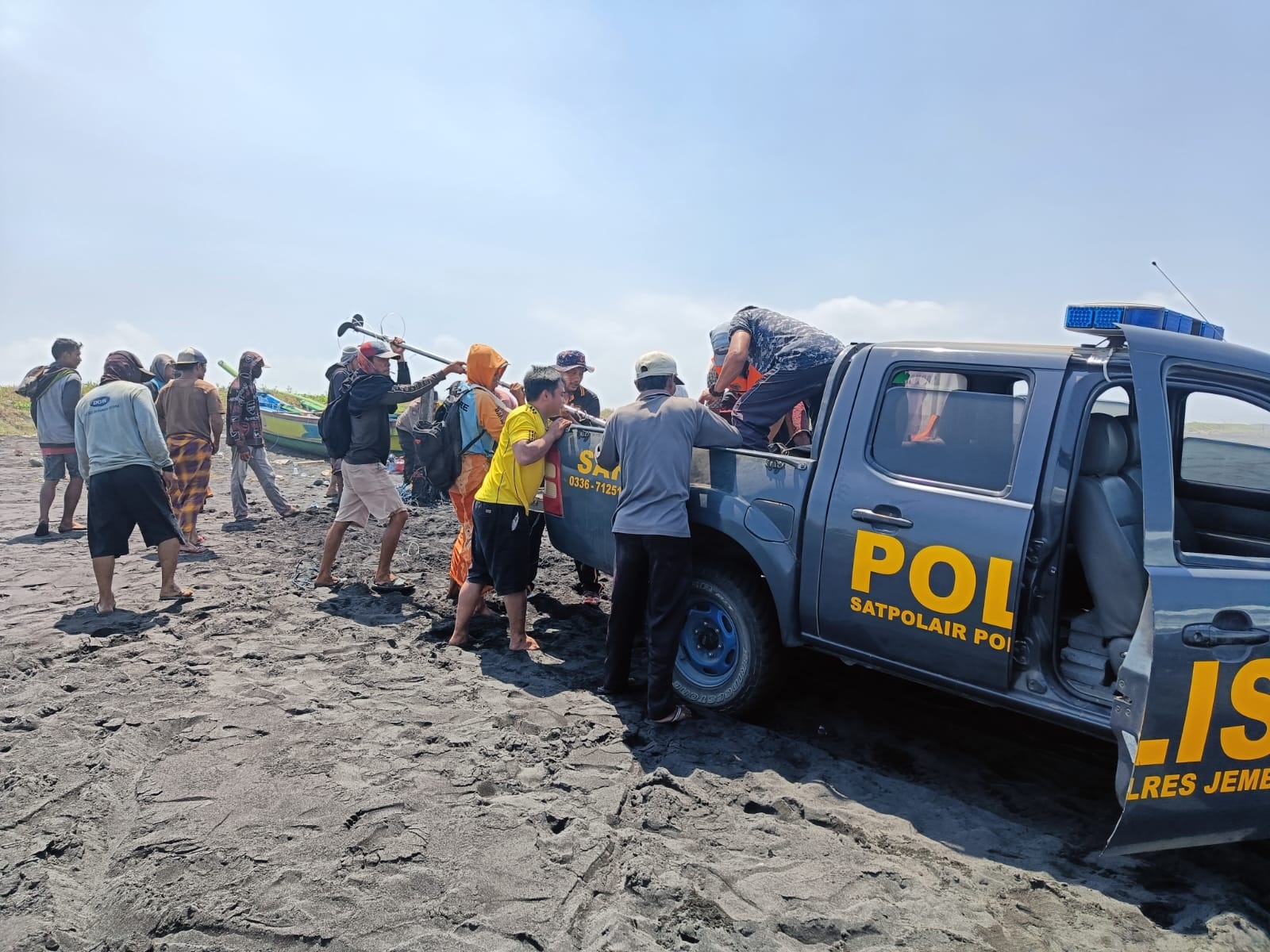 AMANKAN JUKUNG: Anggota Satpolair Polres Jember di Puger bersama nelayan Paseban saat mengevakuasi jukung milik korban yang ditemukan di Pantai Paseban, Kencong, Minggu (24/09).