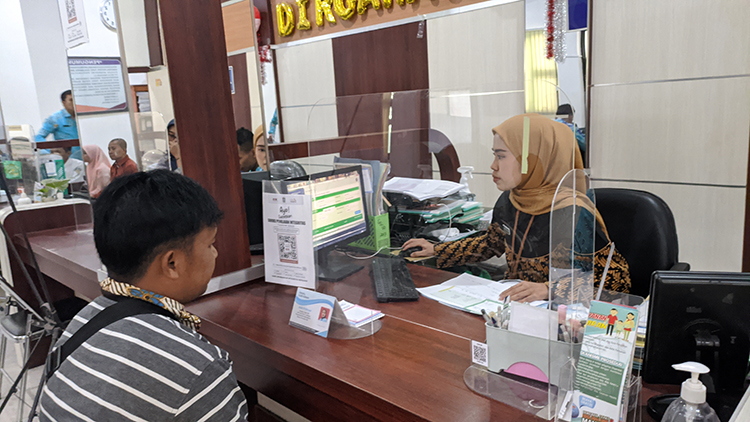 DILAYANI: Petugas pencatatan sipil saat memberikan pelayanan kepada masyarakat di kantor Dispendukcapil.