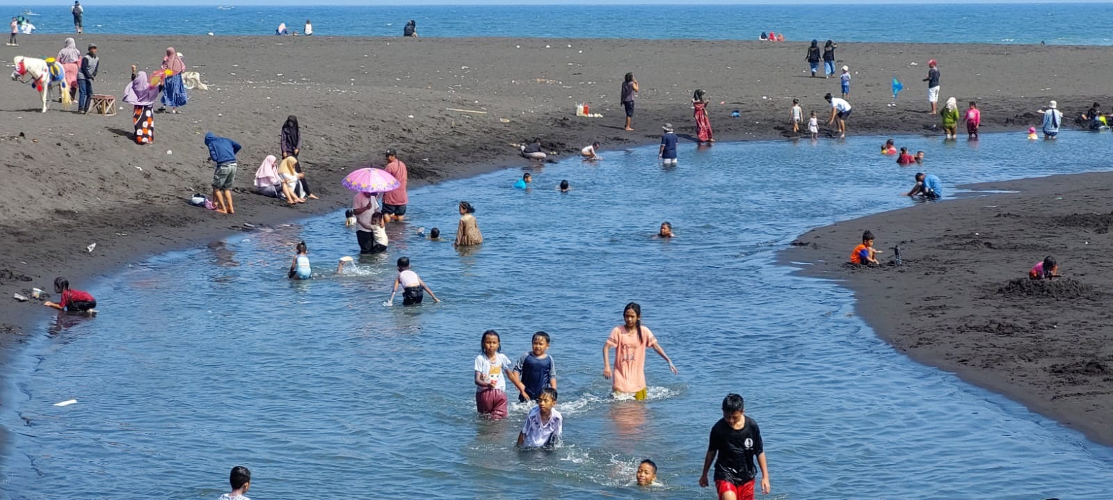 RAMAI: Pengunjung Pantai Cemara di Dusun Getem, Desa Mojomulyo, Puger. Mereka memilih mandi di muara bekas Plawangan dan jauh dari hantaman ombak.