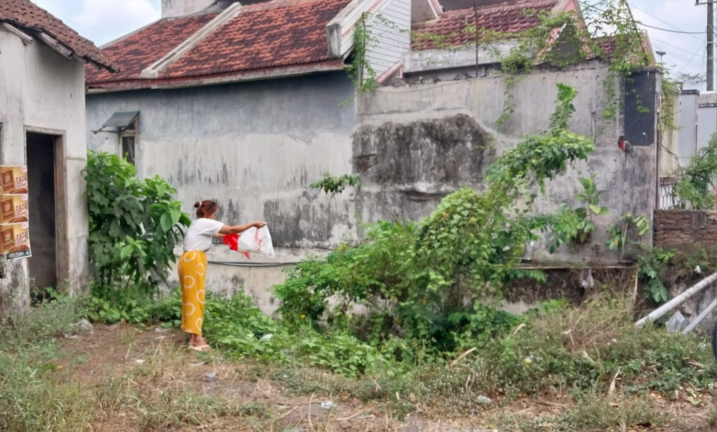 BUANG SAMPAH SEMBARANGAN: Salah seorang warga kedapatan kamera JP Radar Jember, saat buang sampah di sungai. (JUMAI/RJ)