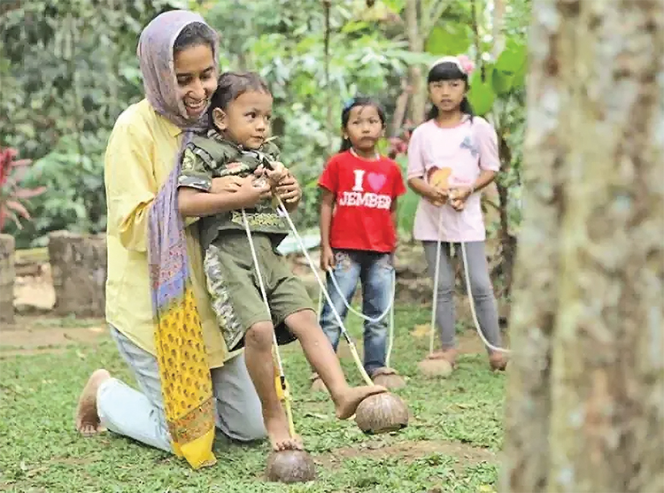 SAYANG ANAK: Direktur Tanoker Farha Ciciek saat mengajari anak-anak untuk bermain permainan tradisional.