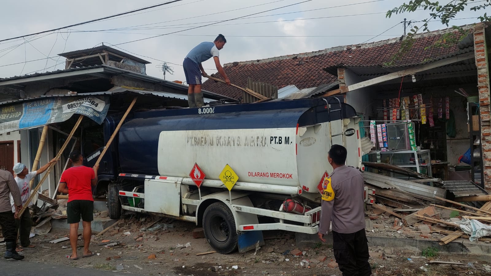 HANCUR: Kondisi truk tangki BE 8214 XY yang disopiri Basit Hakim, 20, warga Kabupaten Probolinggo setelah menabrak dua rumah dan sepeda motor. (JUMAI/RJ)