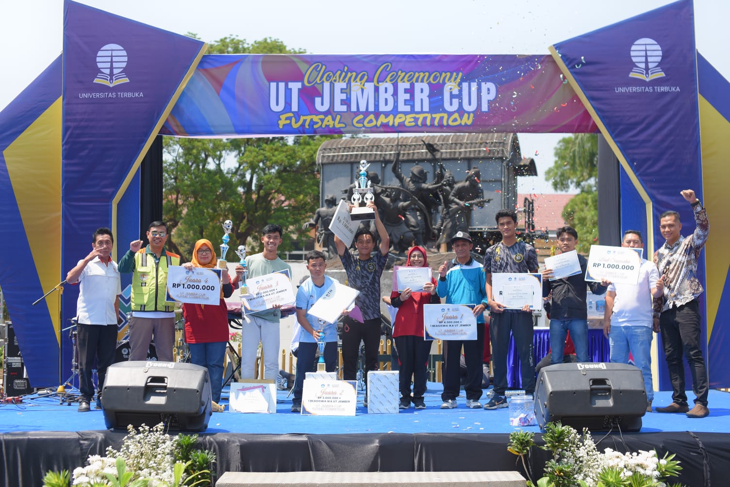 Para pemenang UT Jember Cup "Futsal Competition 2023" berfoto bersama Direktur UT Jember, Barokah Widuroyekti, M.Pd dan Tamu undangan pada closing ceremony di Monumen Gerbong Maut, Alun-alun Bondowoso