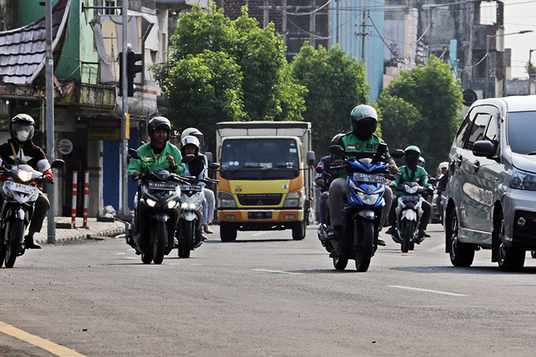  MENJEMPUT REZEKI: Ojol yang melintas di jalan raya kerap ditemui saat ini. Sayangnya, mereka mulai mengeluhkan kehadiran ojol lokal.