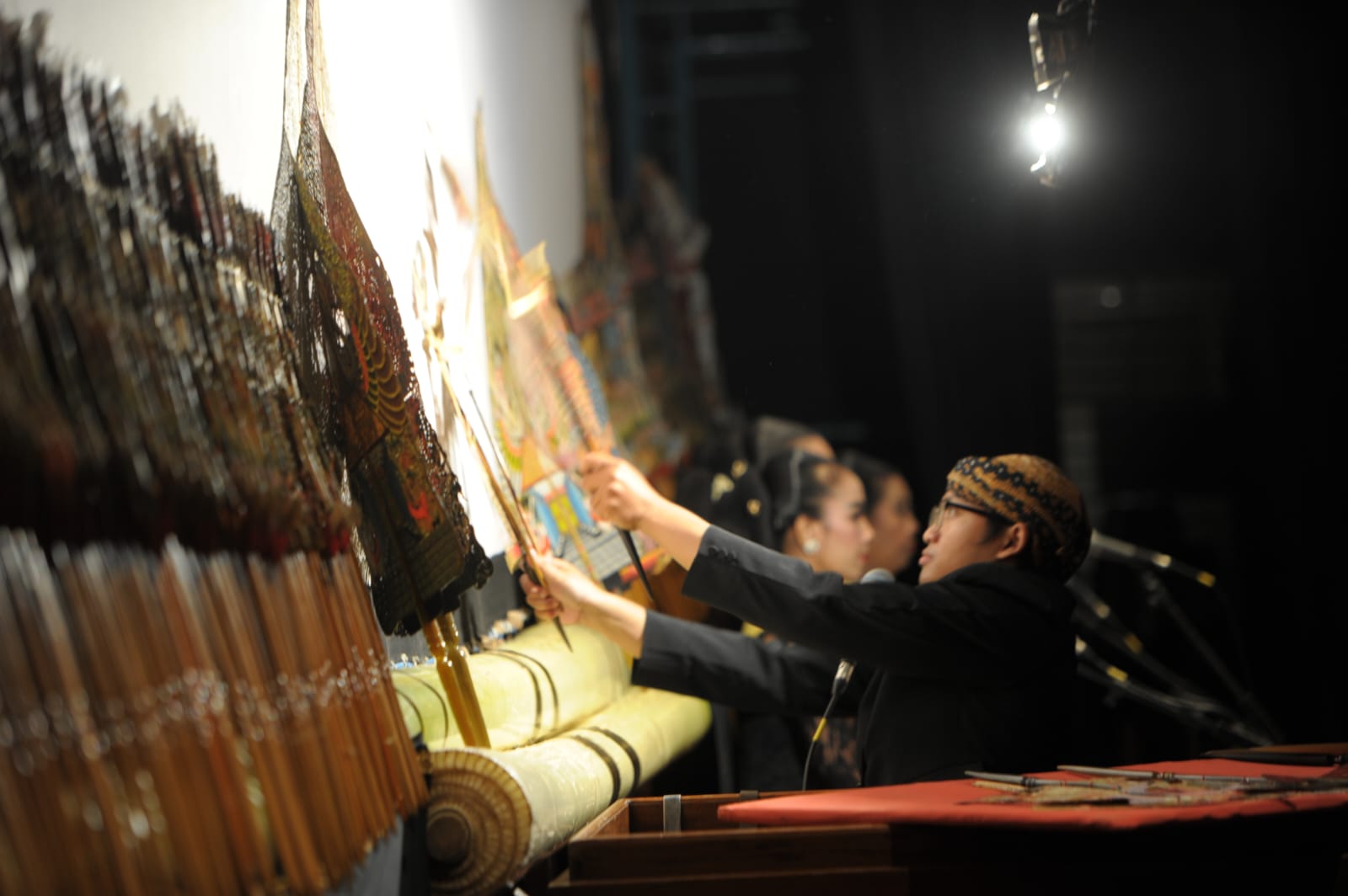 DINIKMATI: Dalang muda Jember menunjukan kebolehannya dalam memainkan wayang kulit.