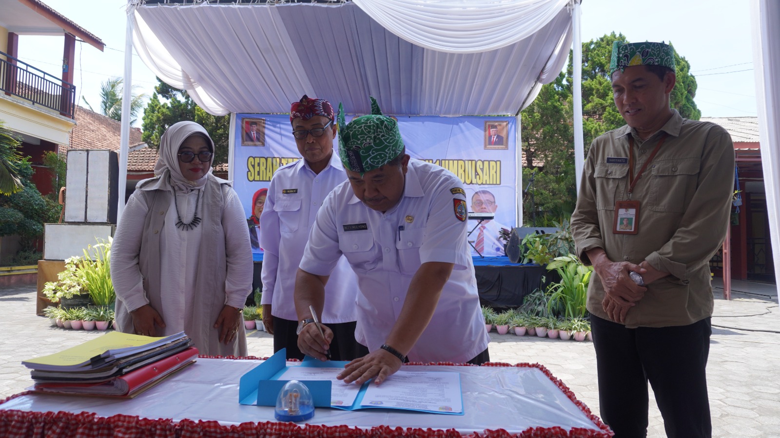PENANDATANGANAN: Hadi Mulyono Kepala Dinas Pendidikan Jember saat menandatangani sertijab Kepala SMPN 1 Umbulsari dari Harnik Purwati (purna tugas) kepada Ruda