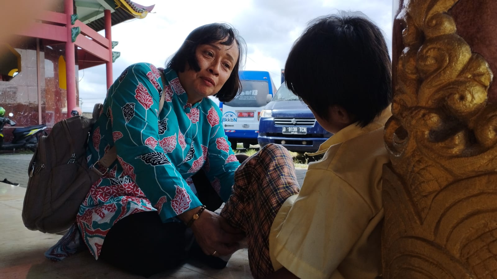 CURAHKAN PERHATIAN: Nur Hasiyati, guru pendamping, memasangkan kaus kaki SA.