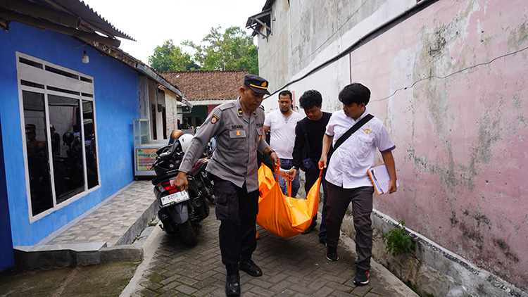 DIEVAKUASI: Anggota Polsek Patrang bersama Satreskrim Polres Jember saat mengevakuasi warga Gebang yang meninggal, untuk dibawa ke kamar mayat RSD dr Soebandi Jember, Rabu (13/12) siang.