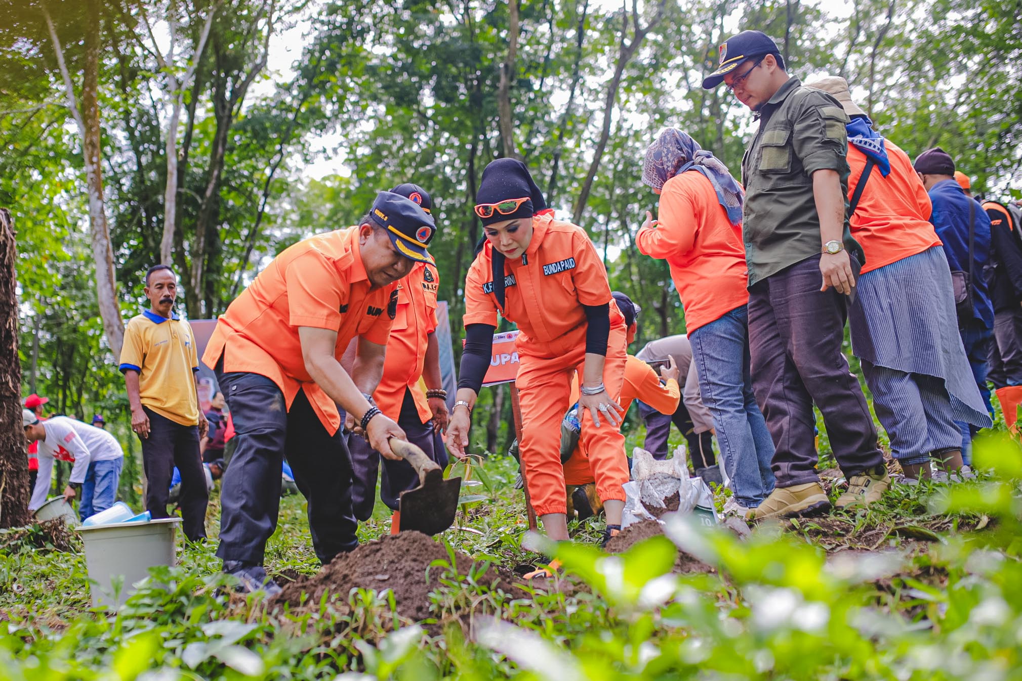 PEDULI ALAM: Bupati Jember Hendy Siswanto bersama Ketua TP PKK Kasih Fajarini menanam pohon di pinggir sungai Kalijompo.