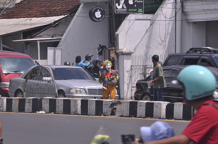 BAGAIMANA INI?: Badut bersaing dengan pengamen di sekitar Geladak Kembar dengan membawa anak.