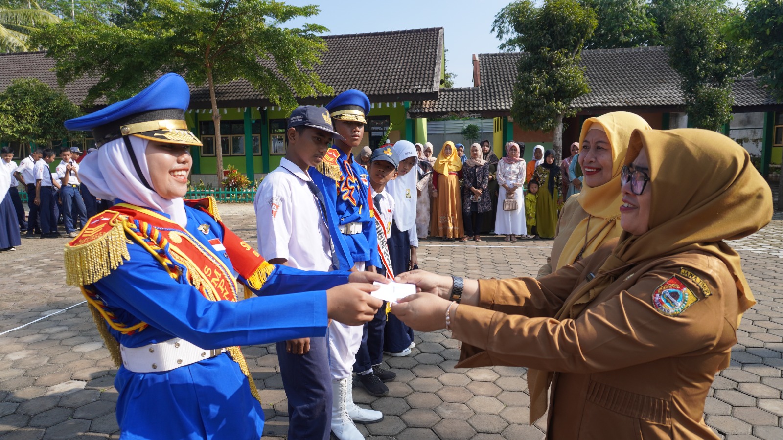 HADIRKAN ORANG TUA: Hermin Agustini, Kepala SMPN Bangsalsari 3, memberikan hadiah lomba kepada siswa yang berprestasi dan disaksikan orang tua pada apel pagi, kemarin (2/1). (JUMAI/RJ)