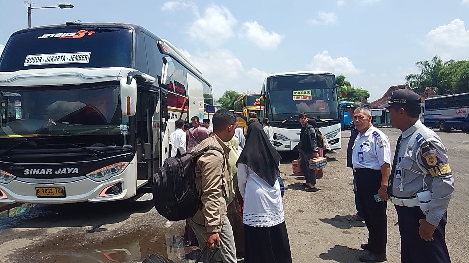 MENJAGA: Petugas melakukan pengecekan armada bus yang bakal berangkat dari Terminal Tawang Alun.