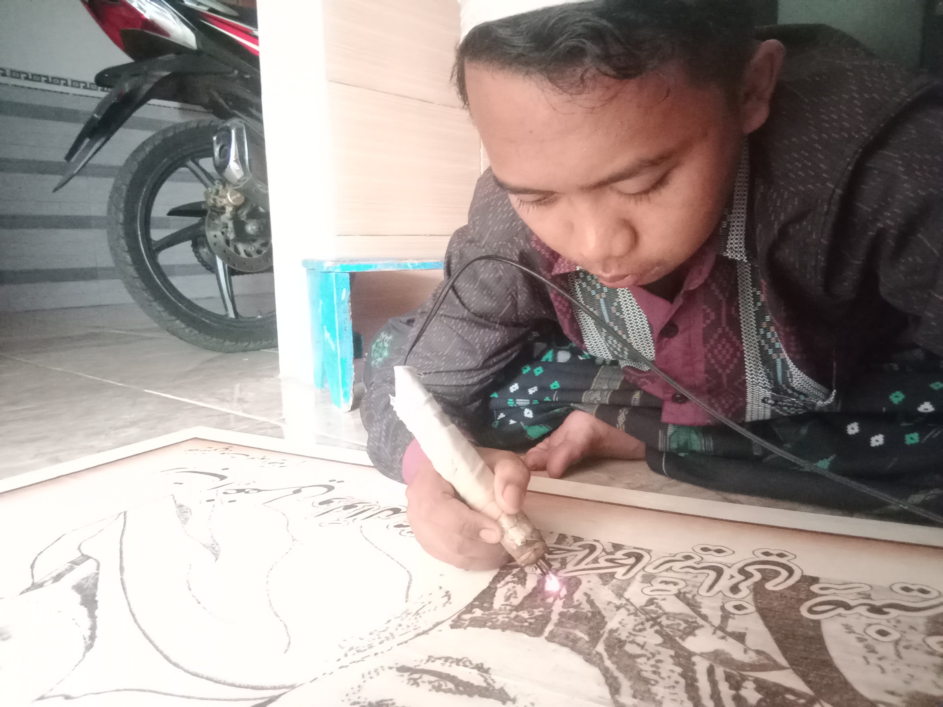 MENGUNTUNGKAN: Ali Imron sedang membuat pesanan kaligrafi.