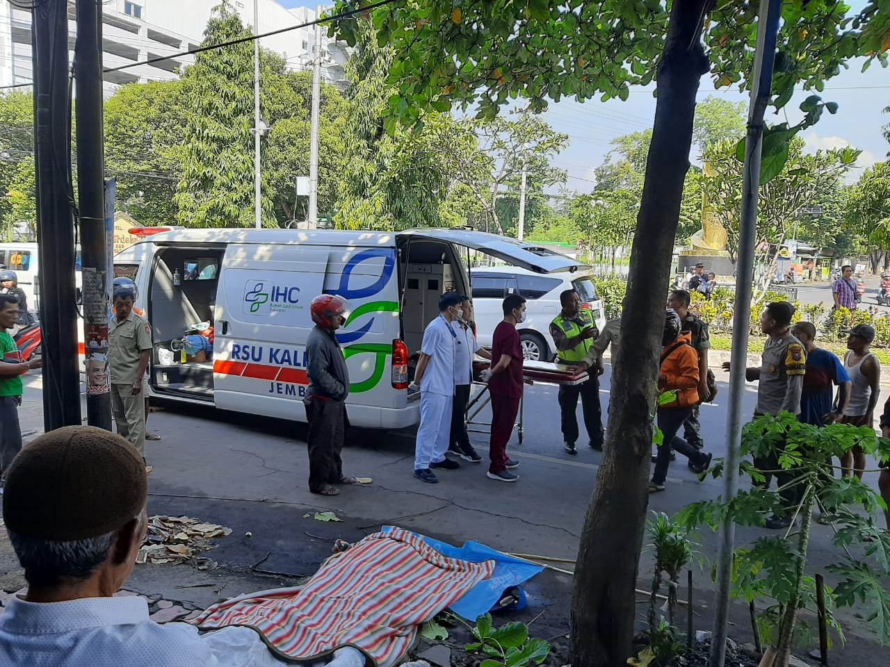 LANGSUNG DIEVAKUASI: Polisi dan petugas medis langsung mengevakuasi korban yang tersengat arus listrik di Jalan Gajah Mada, Kaliwates, kemarin pagi (9/1).