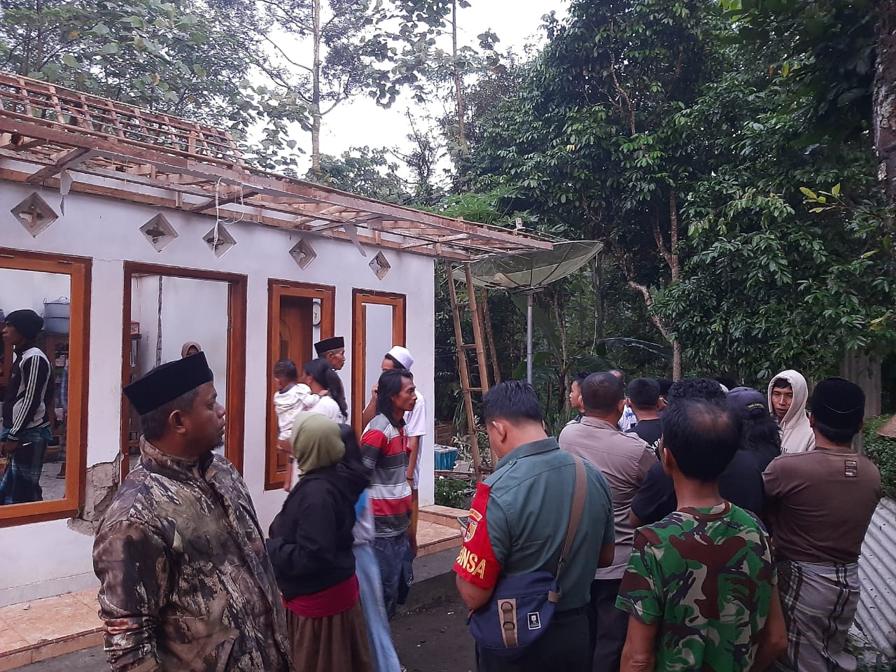 RUSAK PARAH: Warga sekitar saat mendatangi rumah yang tersambar petir, Selasa (9/1).