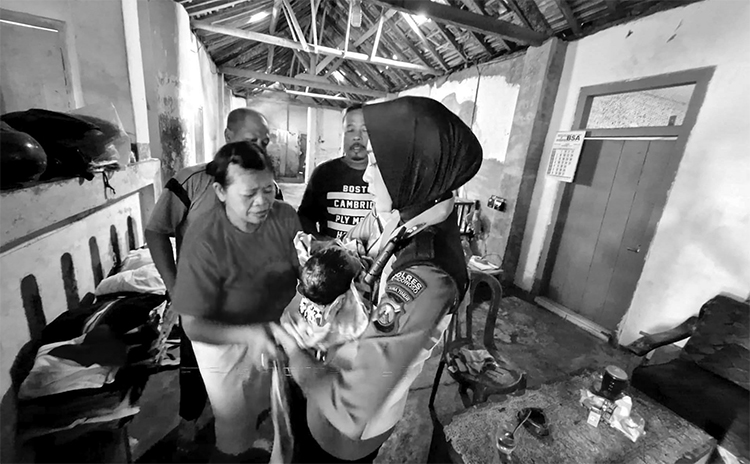 DIGENDONG: Polisi yang berada di lokasi kejadian menggendong bayi perempuan, kemarin (10/1).