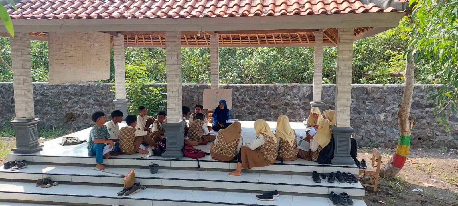 SEMANGAT: Siswa kelas VII B SMPN 3 Puger saat mengikuti pembelajaran di gazebo dengan tetap semangat. (JUMAI/RJ)