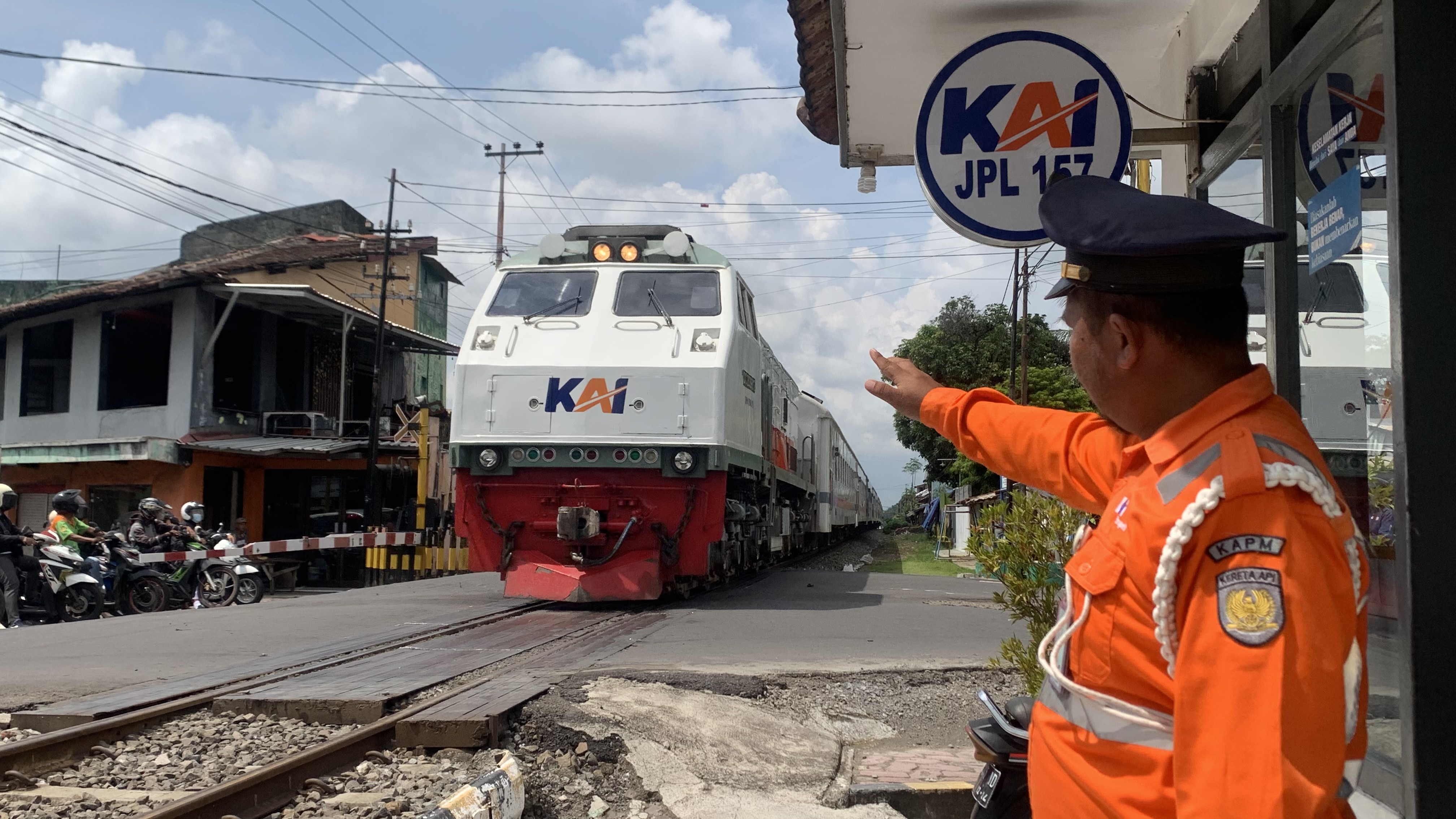 RAMAH: Farid, salah satu penjaga palang pintu perlintasan kereta api, ketika melambaikan tangan kepada masinis.  &nbsp;
