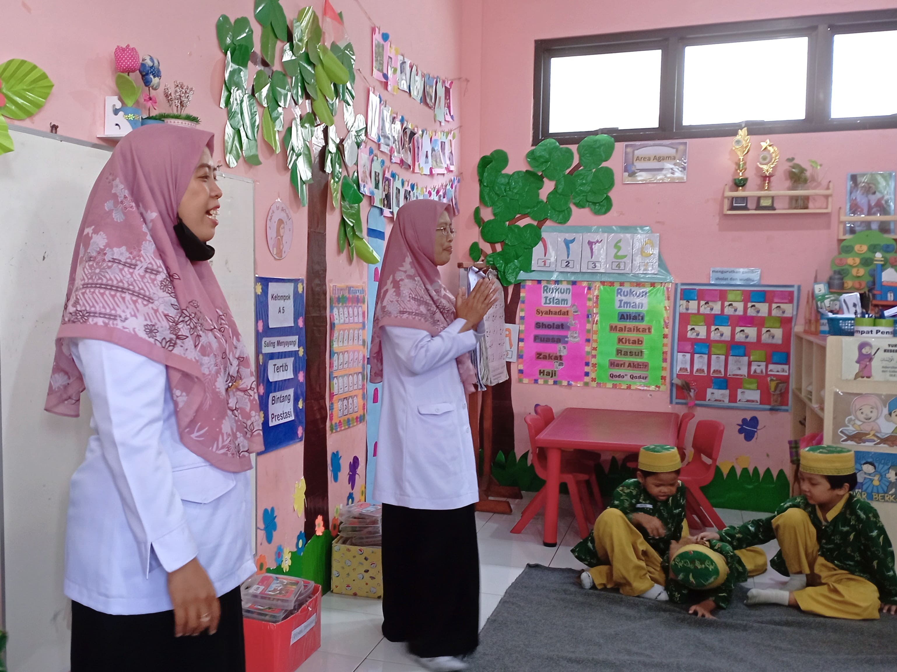 MENGAJAR: Dua guru TK memberikan pelajaran kepada anak didiknya di TK Al Amien Jember.(SUTAN CADENA/RADAR JEMBER)